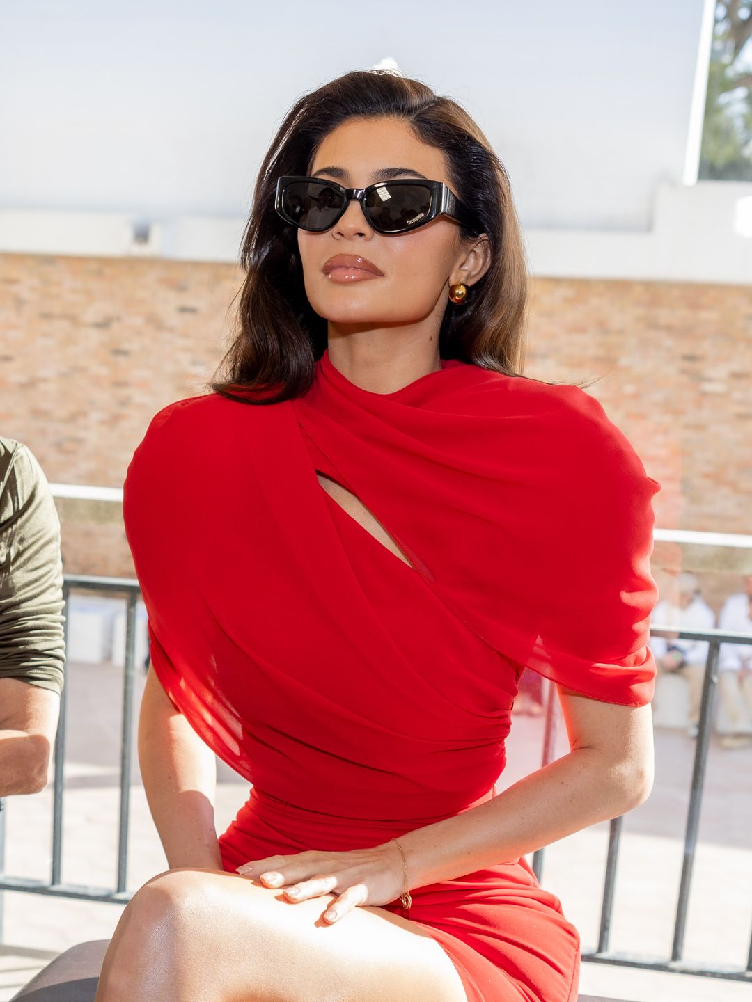 Kylie Jenner attends the "Les Sculptures" Jacquemus' Fashion Show in a red dress and black sunglasses