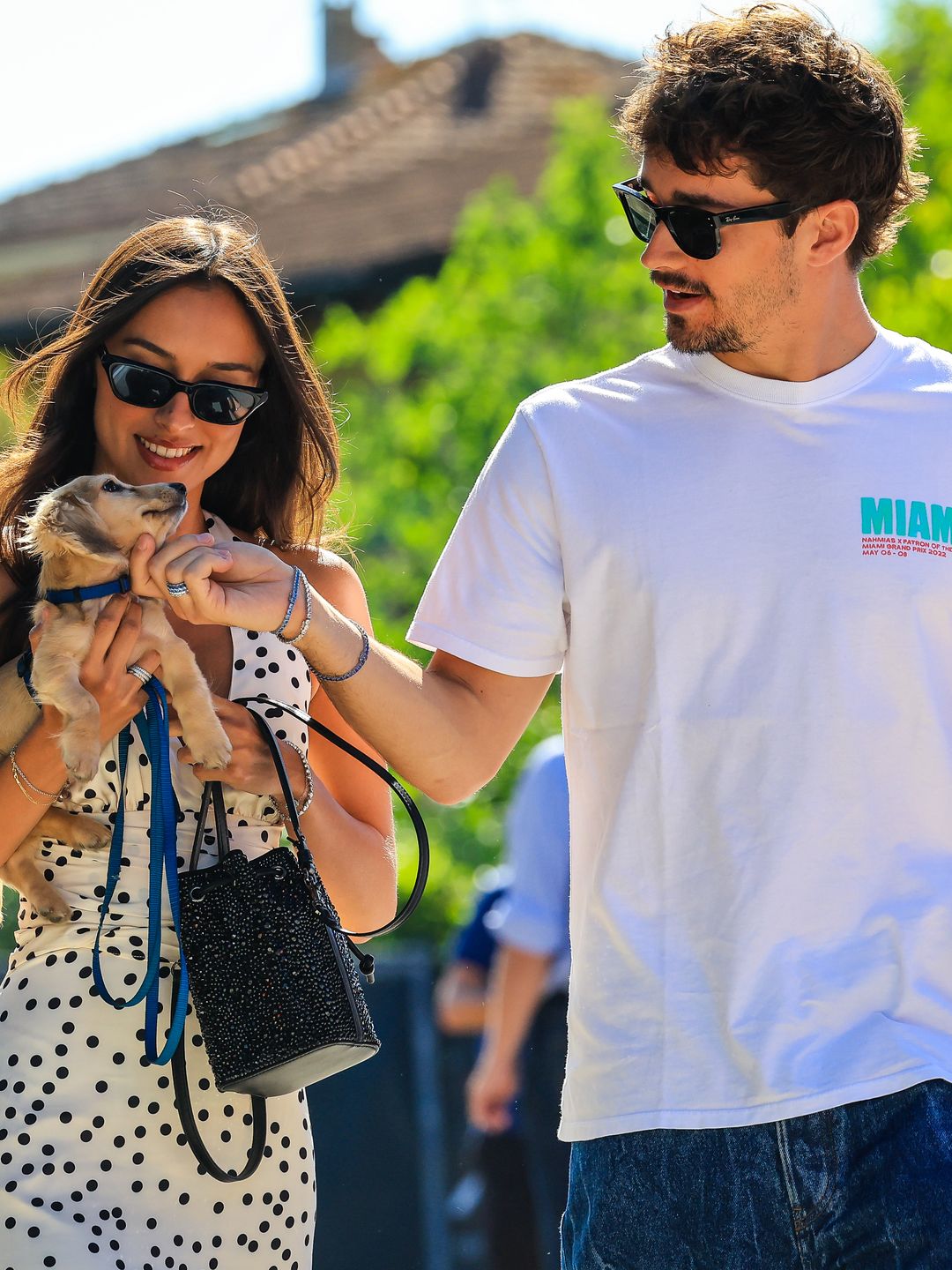 Charles Leclerc walking with Alexandra Saint Mleux, who is carrying a dog