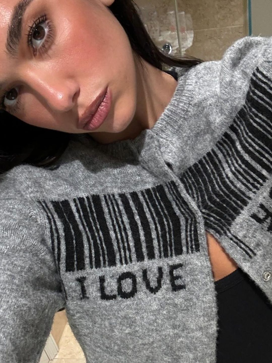 Dua Lipa poses in a grey cardigan on her Instagram