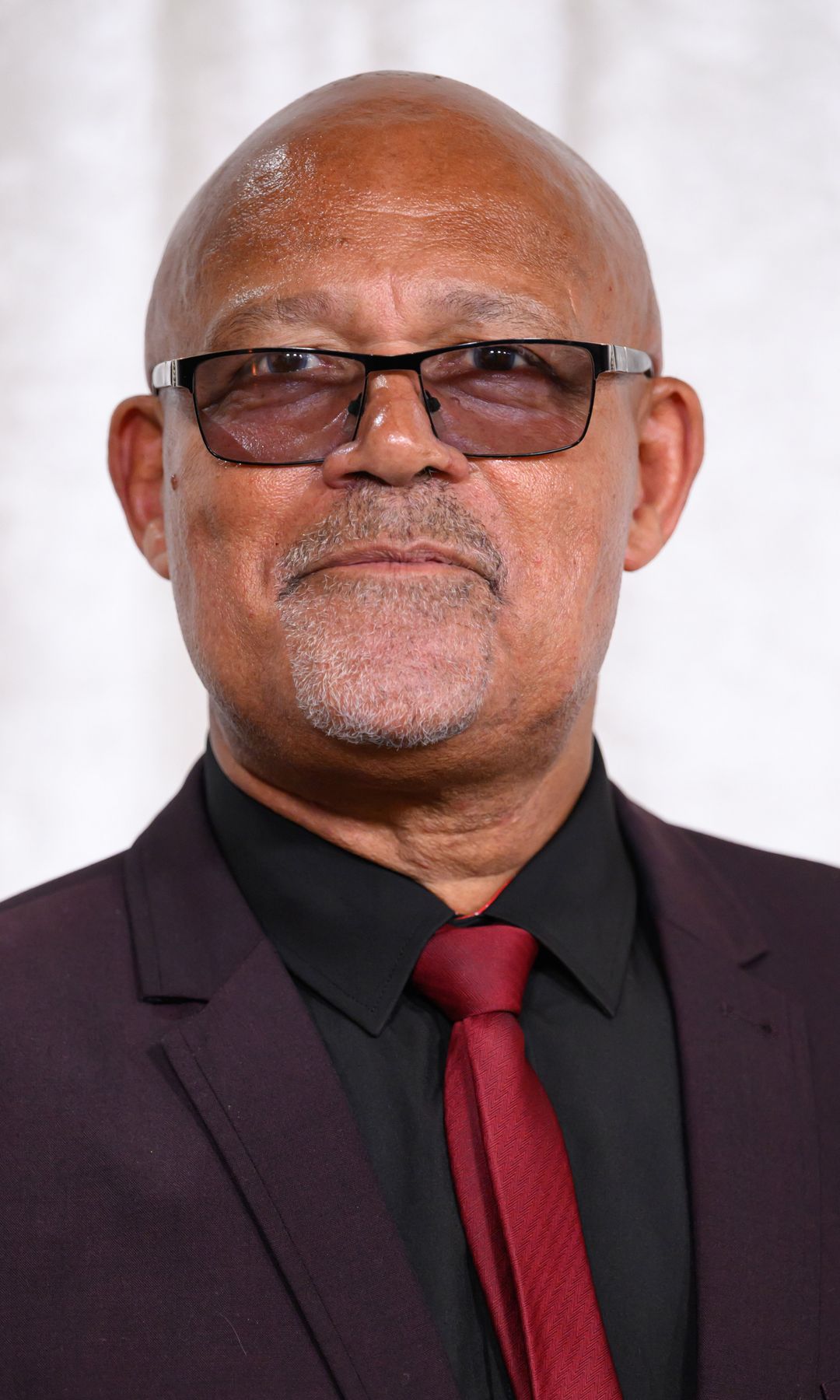 Louis Emerick in a suit and shaded glasses