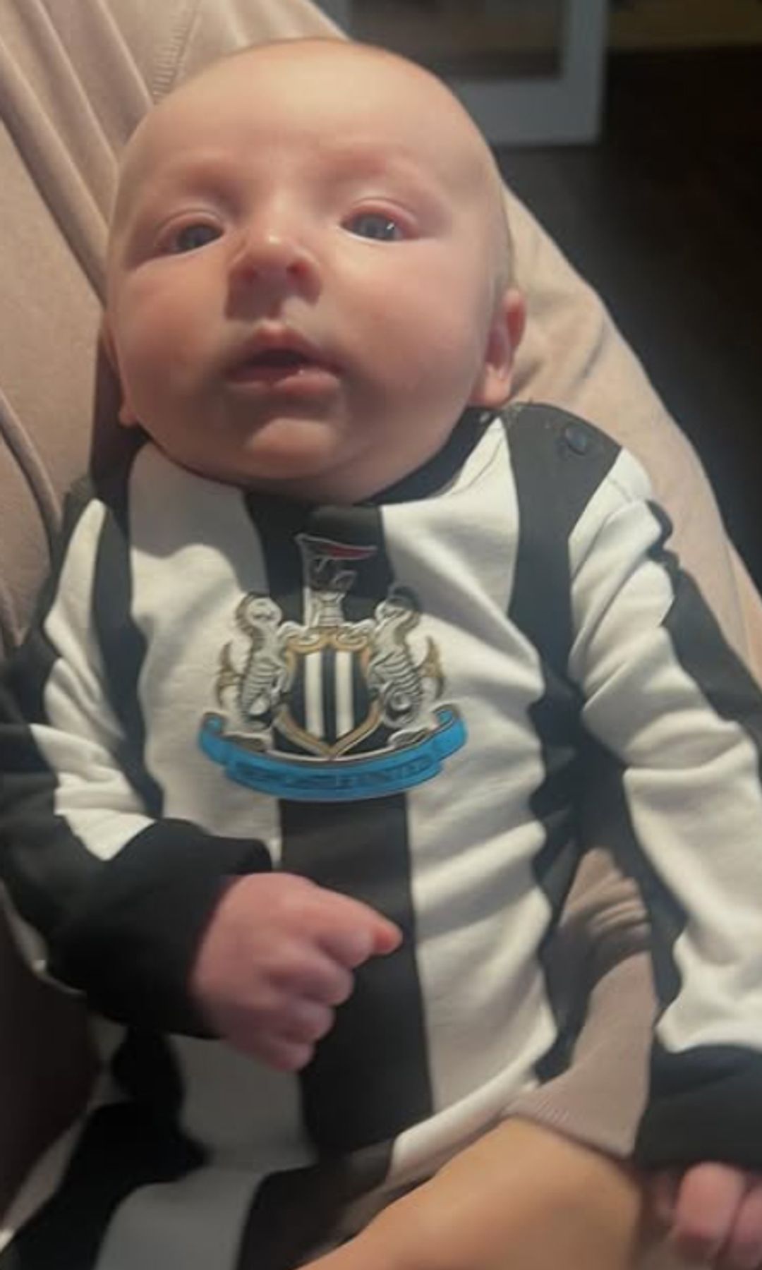 A baby in a Newcastle football kit