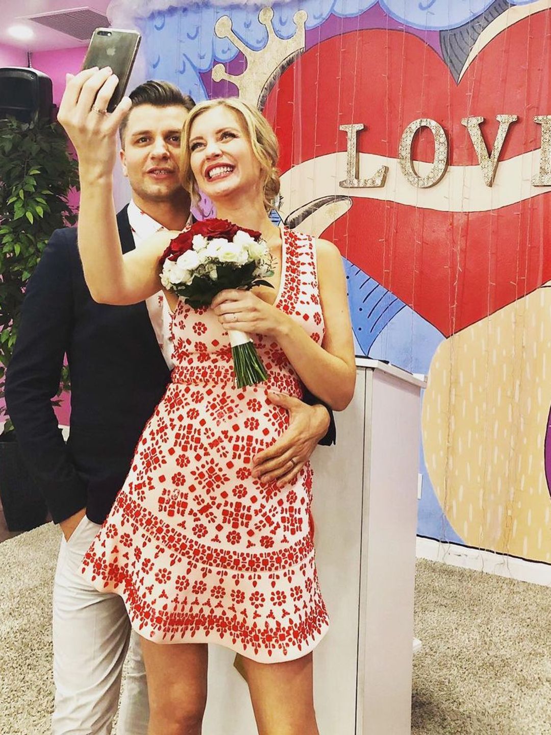 Pasha Kovalev placing his hand on Rachel Riley's baby bump on their wedding day
