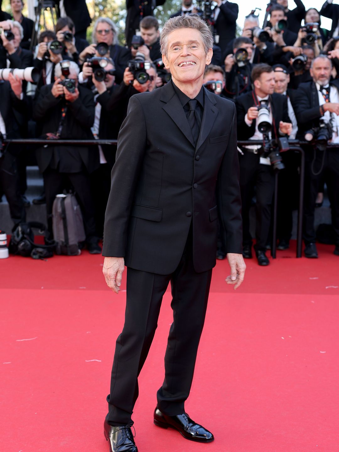 Willem Dafoe in a black suit