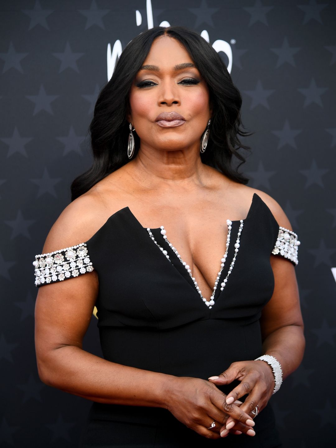 Angela Bassett wearing a black plunging gown on the red carpet 
