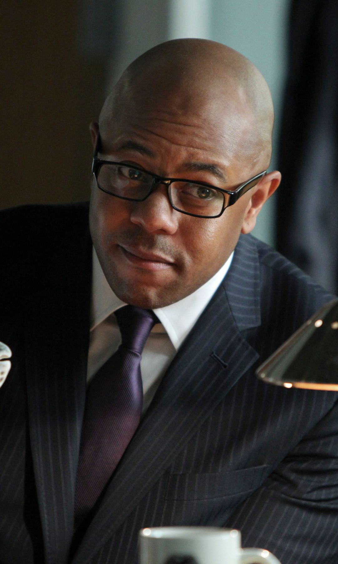 Still image of Rockmond Dunbar sitting at a desk with a seashell in The Mentalist