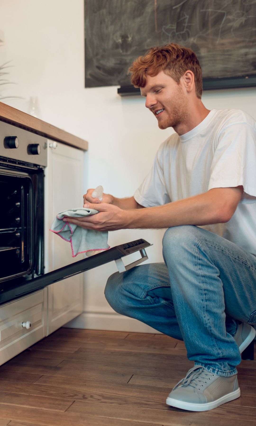 man cleaning oven