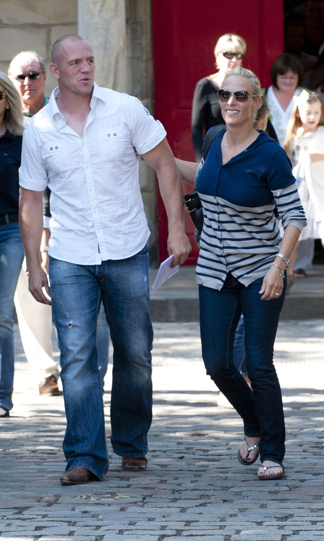 Zara Tindall with a blue pedicure holding Mike Tindall's arm
