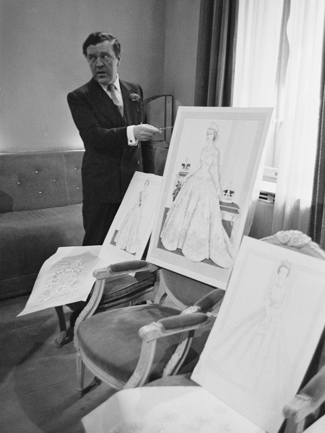 13th June 1953:  Couturier Norman Hartnell (1901 - 1978) with his design for the Queen's coronation dress.  (Photo by Haywood Magee/Picture Post/Getty Images)