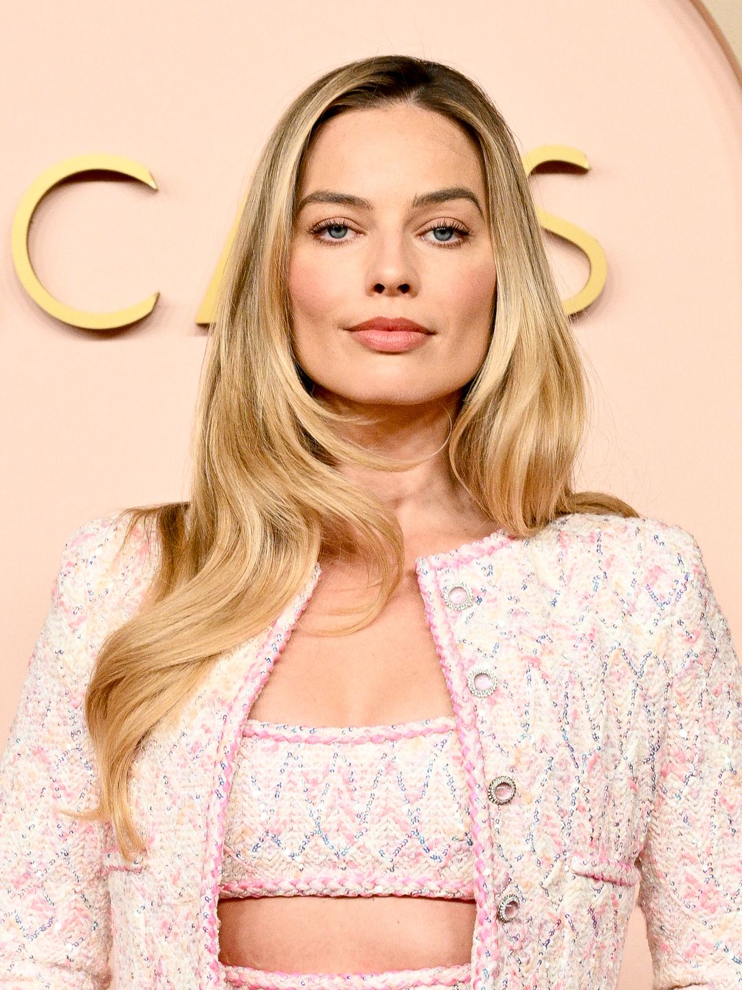 Margot Robbie wearing a pink jacket and crop top at the Oscars Luncheon
