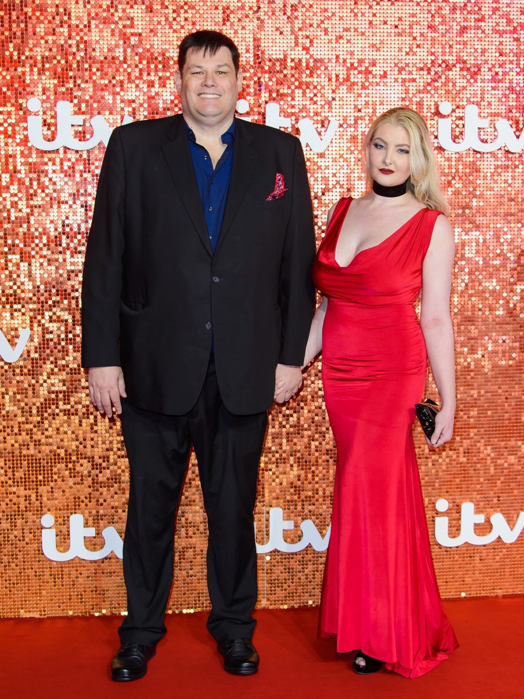 Mark Labbett in a black suit and Katie Labbett in a red dress