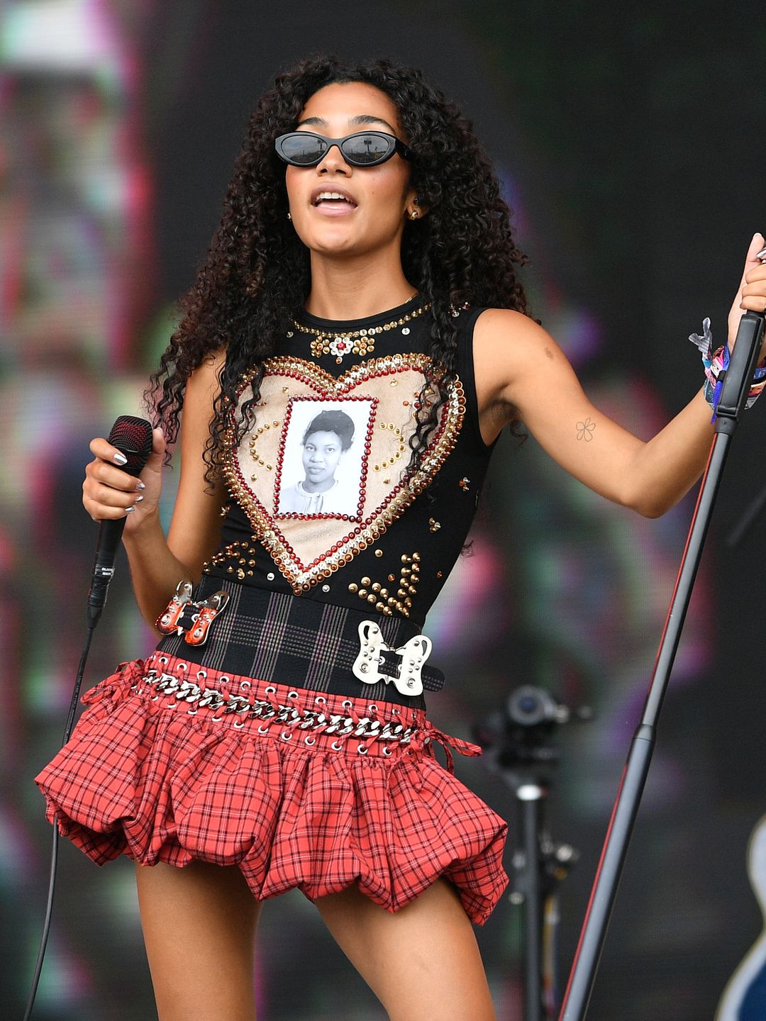 Olivia Dean performs on the Pyramid stage during day three of Glastonbury Festival wearing a tartan puffball mini skirt