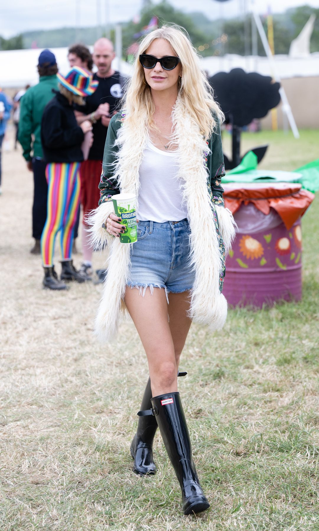 Poppy Delevingne attends day three of Glastonbury Festival at Worthy Farm, Pilton on June 24, 2022 in Glastonbury, England in jean shorts and wellington boots
