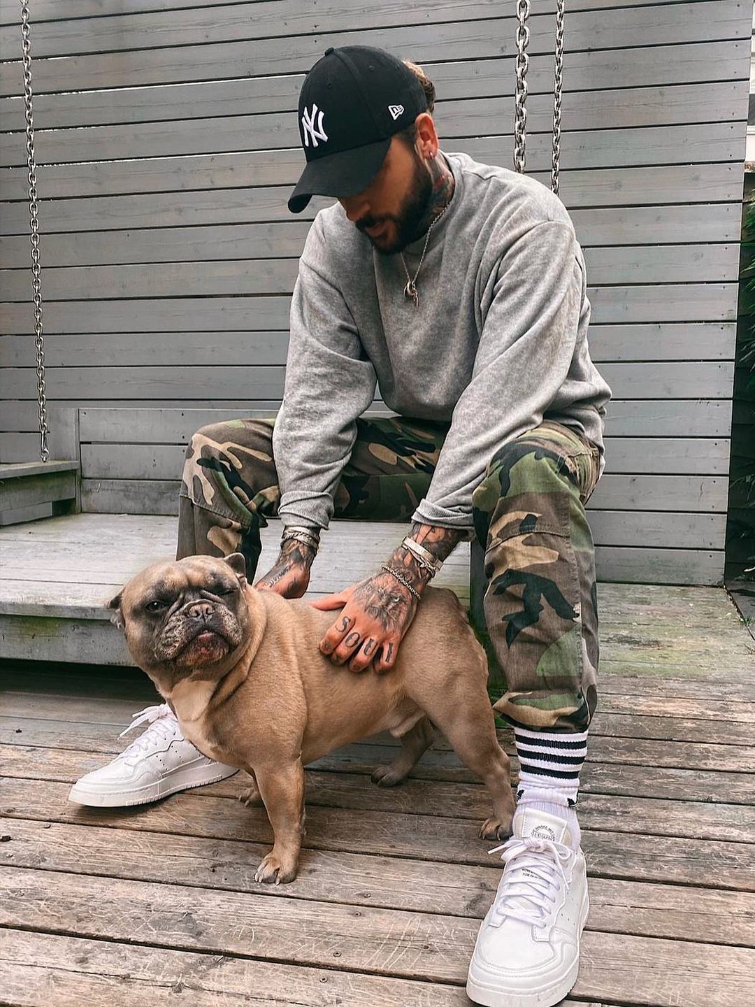 man posing with dog in garden