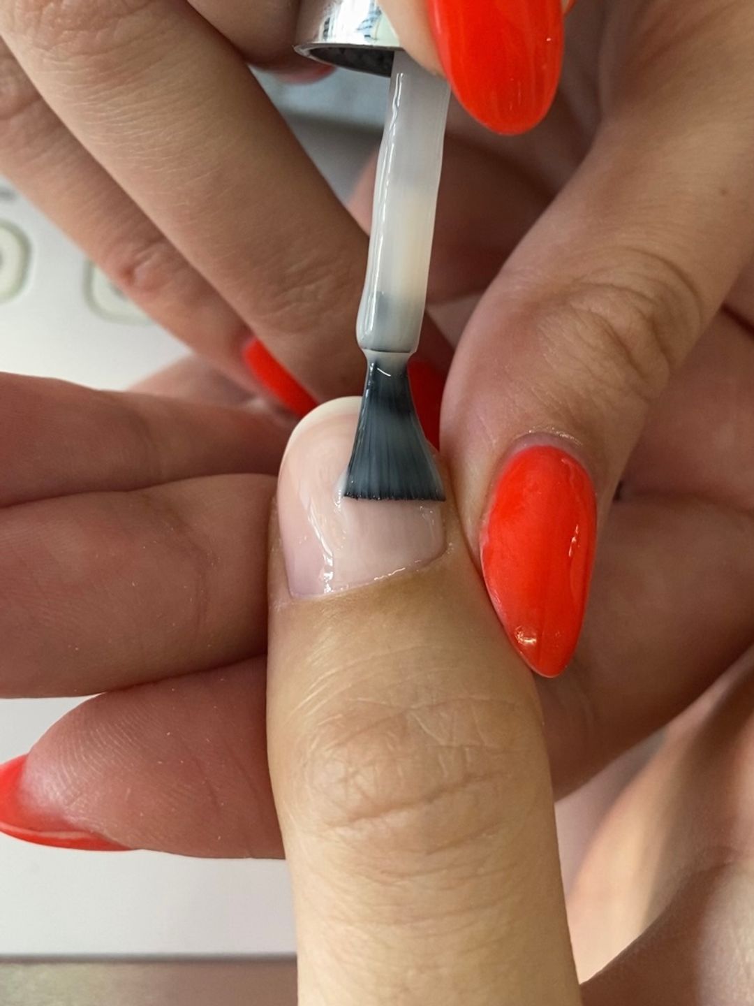 Fingernail with nude layer being applied 