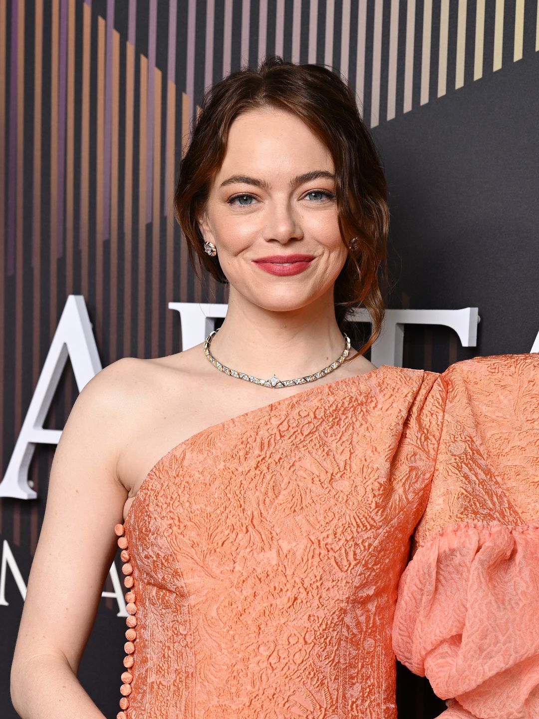 Emma Stone in an orange one-shoulder gown at the BAFTAs 