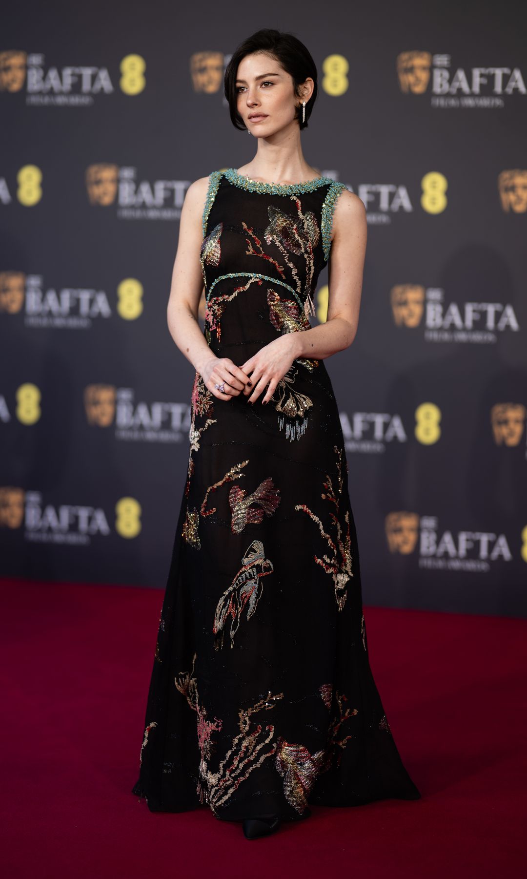 Rapport sur les tendances des BAFTA : les styles du tapis rouge devraient dominer en 2026 1 Gracie Abrams assiste aux EE BAFTA Film Awards 2026 au Royal Festival Hall le 22 février 2026 à Londres, en Angleterre, vêtue d'une robe noire avec un décolleté en perles bleues et un motif abstrait partout.