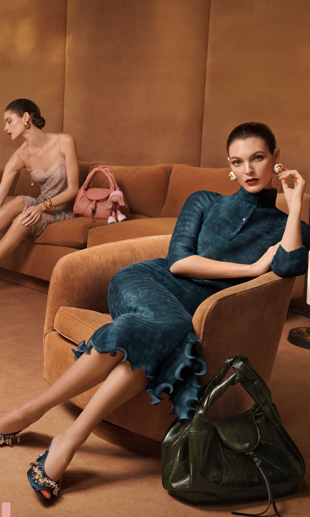 models in tan coloured room in teal, green and sheer clothing