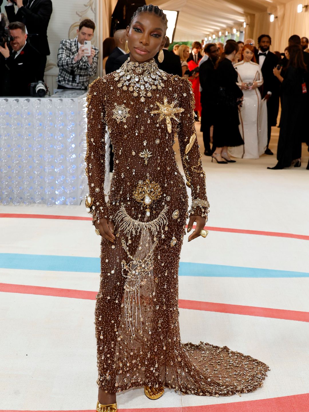 Michaela Coel looked exquisite in an embellished custom Schiaparelli ensemble, topped off with statement jewels by Emefa Cole in SMO Gold, (the first transparent and traceable gold).