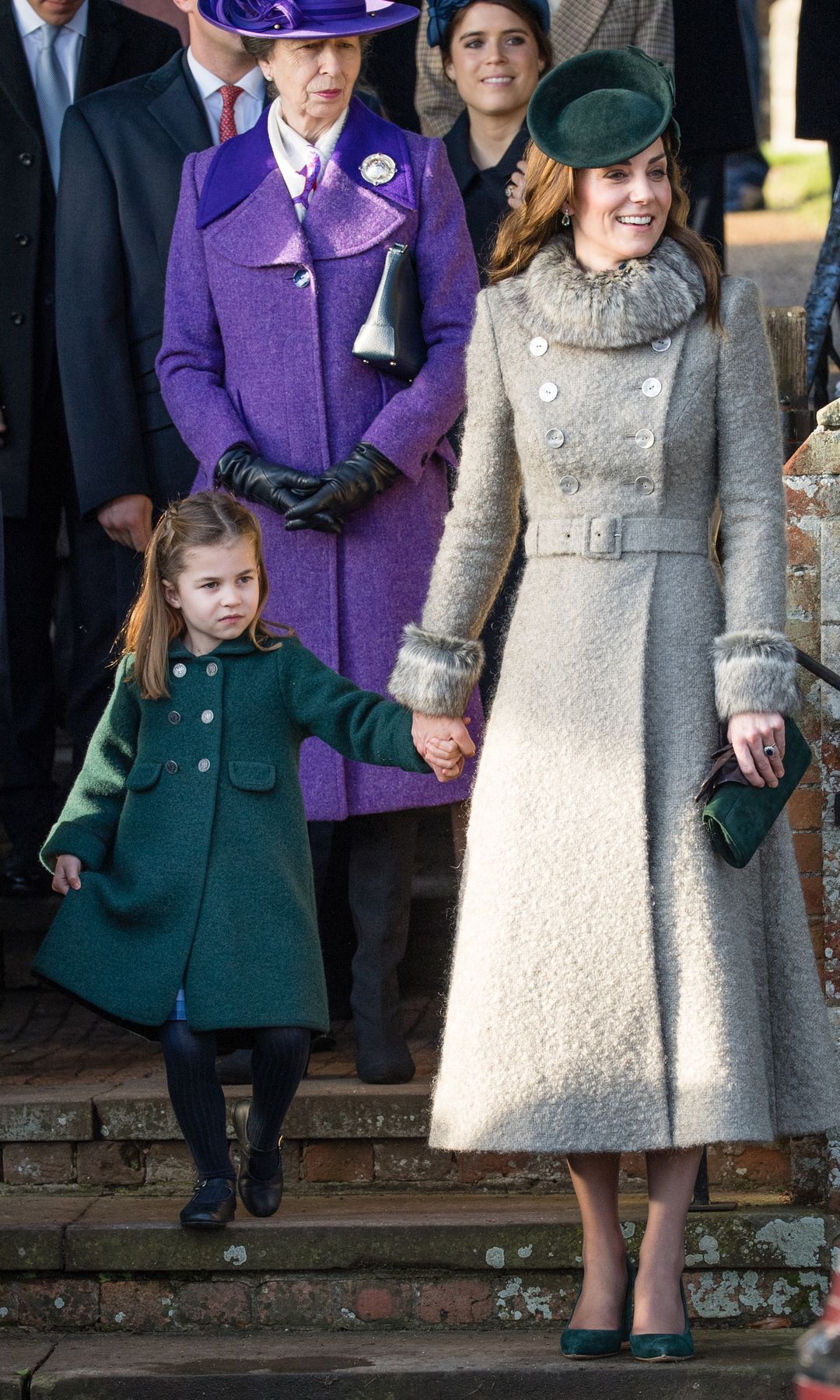 Princess Charlotte curtseying and holding Princess Kate's hand
