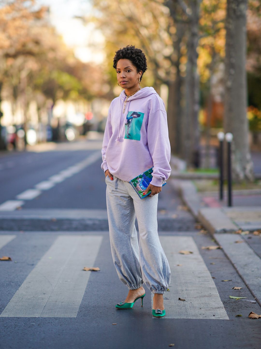 Ellie Delphine pairs her gray sweatpants from Norma Kamali with a clutch from Olympia Le Tan
