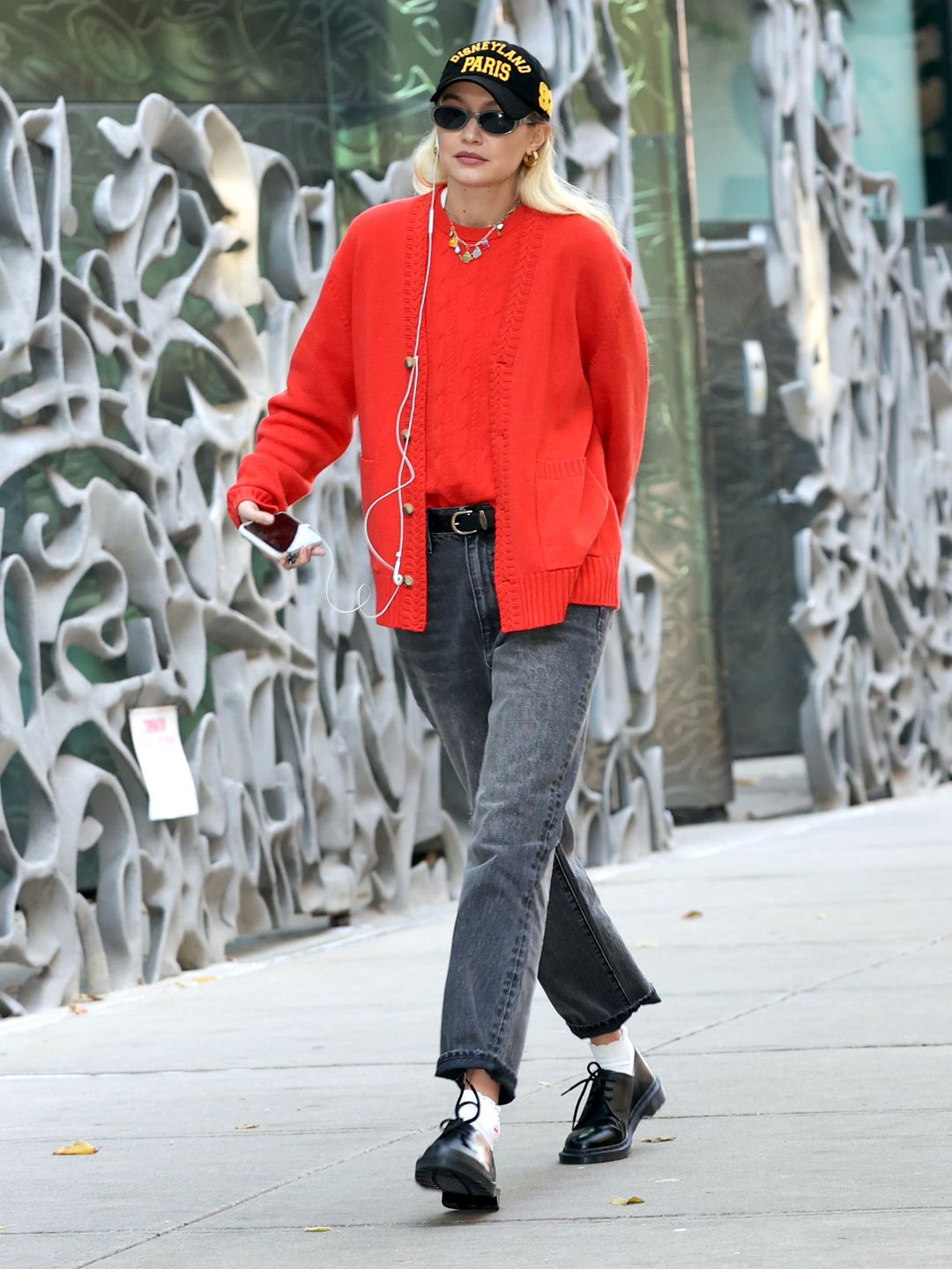 Gigi Hadid takes a walk in NYC wearing a red cardigan and jumper and black jeans 