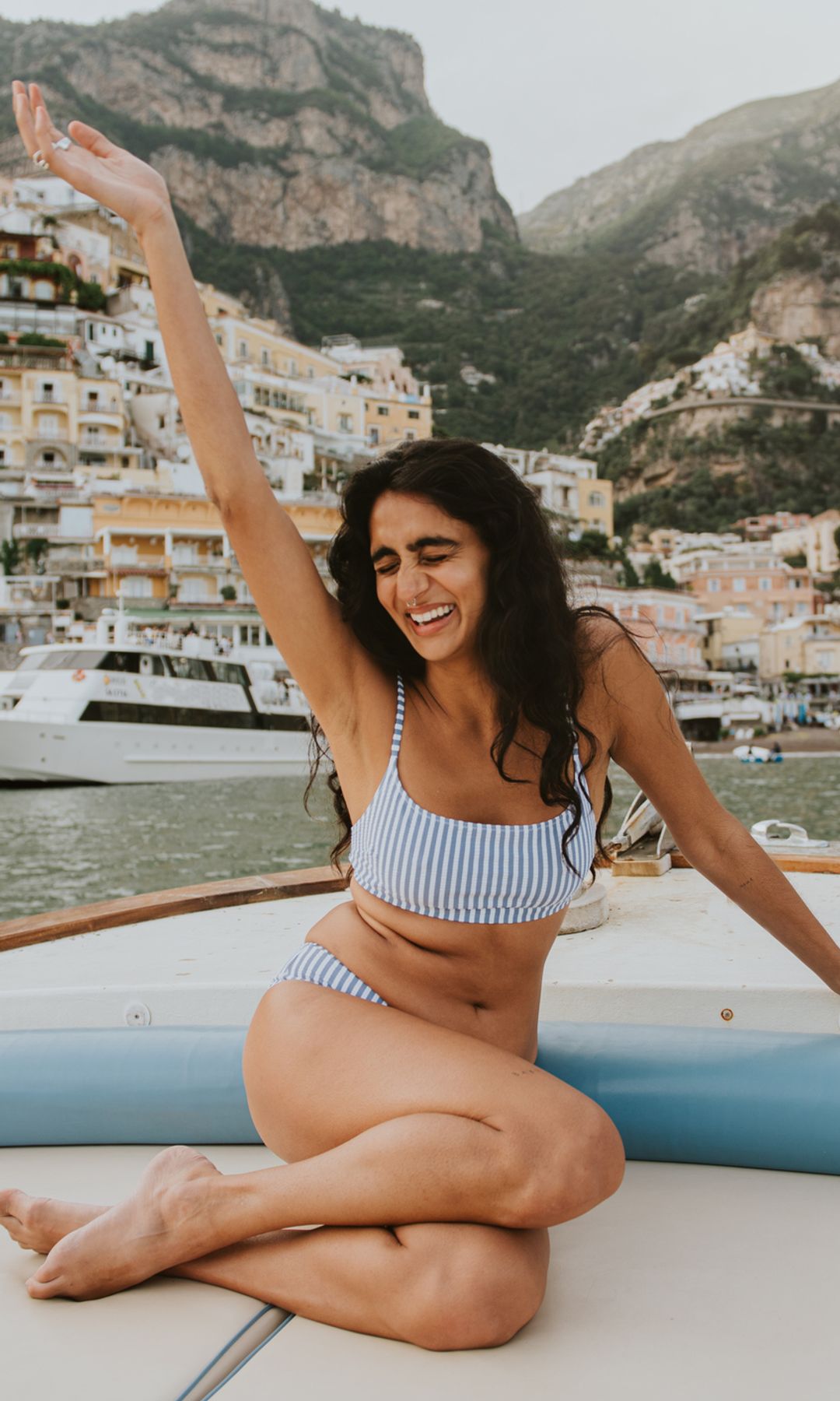 Une femme sur un bateau devant une ville italienne