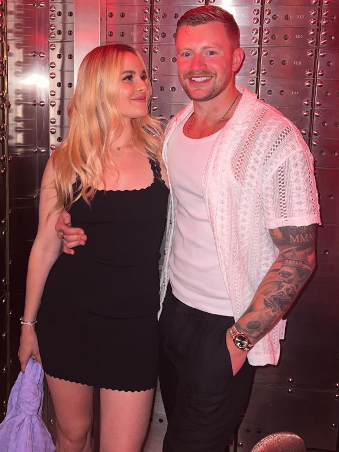 Holly Ramsay in a black dress and Adam Peaty in a white shirt and black trousers