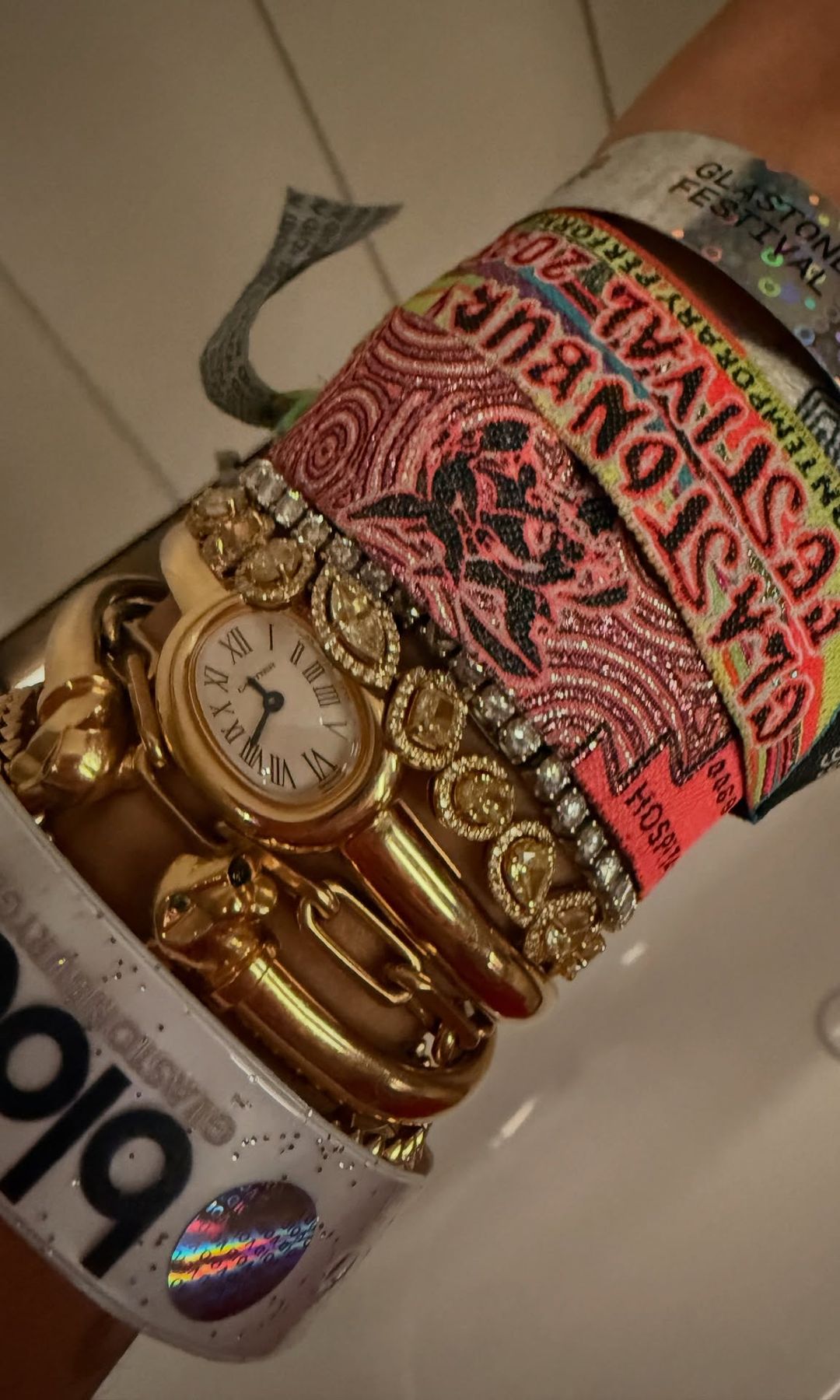 Rita Ora's arm covered in jewellery and festival wristbands