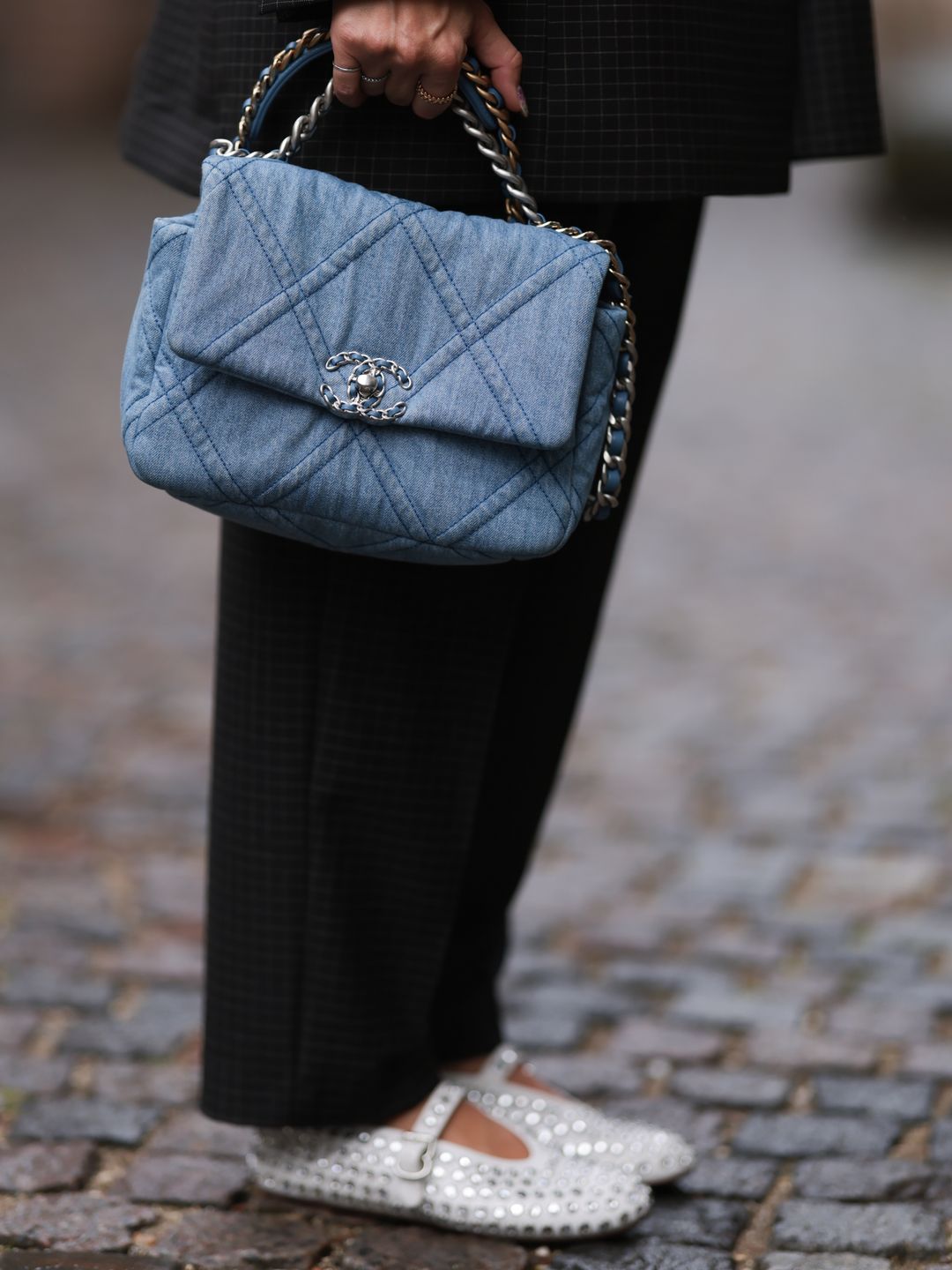 Karin Teigl seen wearing Munthe grey checked blazer jacket with matching suit pants, Chanel light blue denim bag, Alaia white leather studded ballerinas, during the Copenhagen Fashion Week Spring/Summer 2024 on August 09, 2023 in Copenhagen, Denmark. (Photo by Jeremy Moeller/Getty Images)