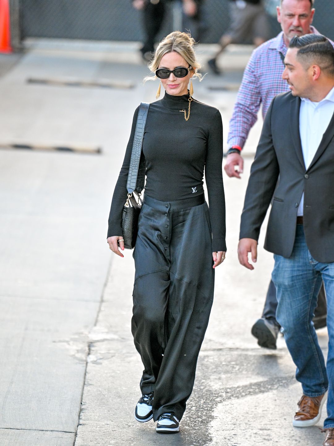 Emily Blunt wearing turtleneck, trousers and Nike Dunks 