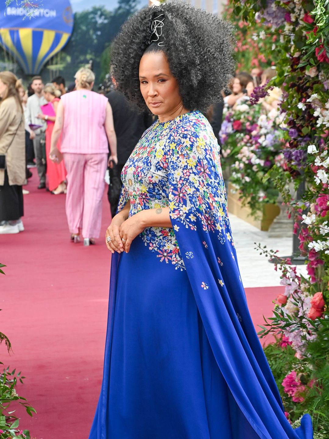 Golda Rosheuvel em vestido floral azul dando um ar de desaprovação