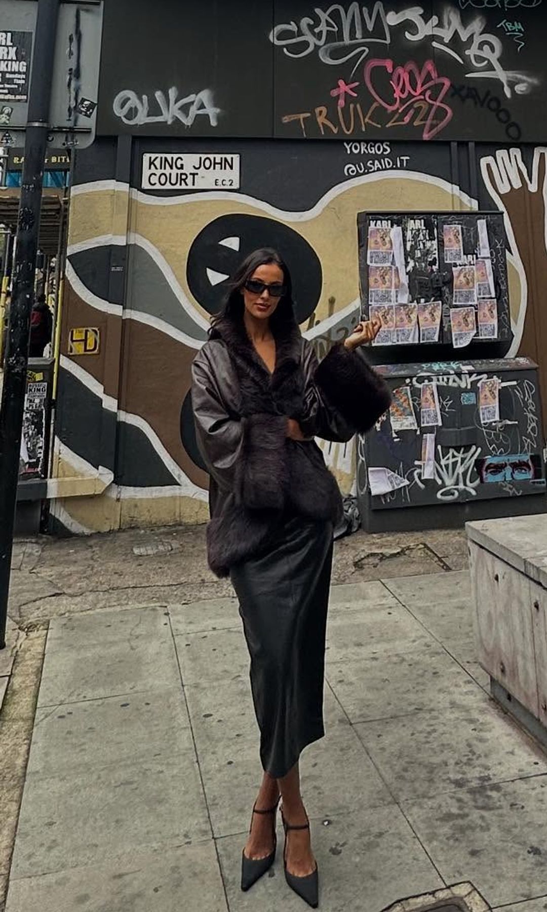 Maya Jama poses in a brown leather coat