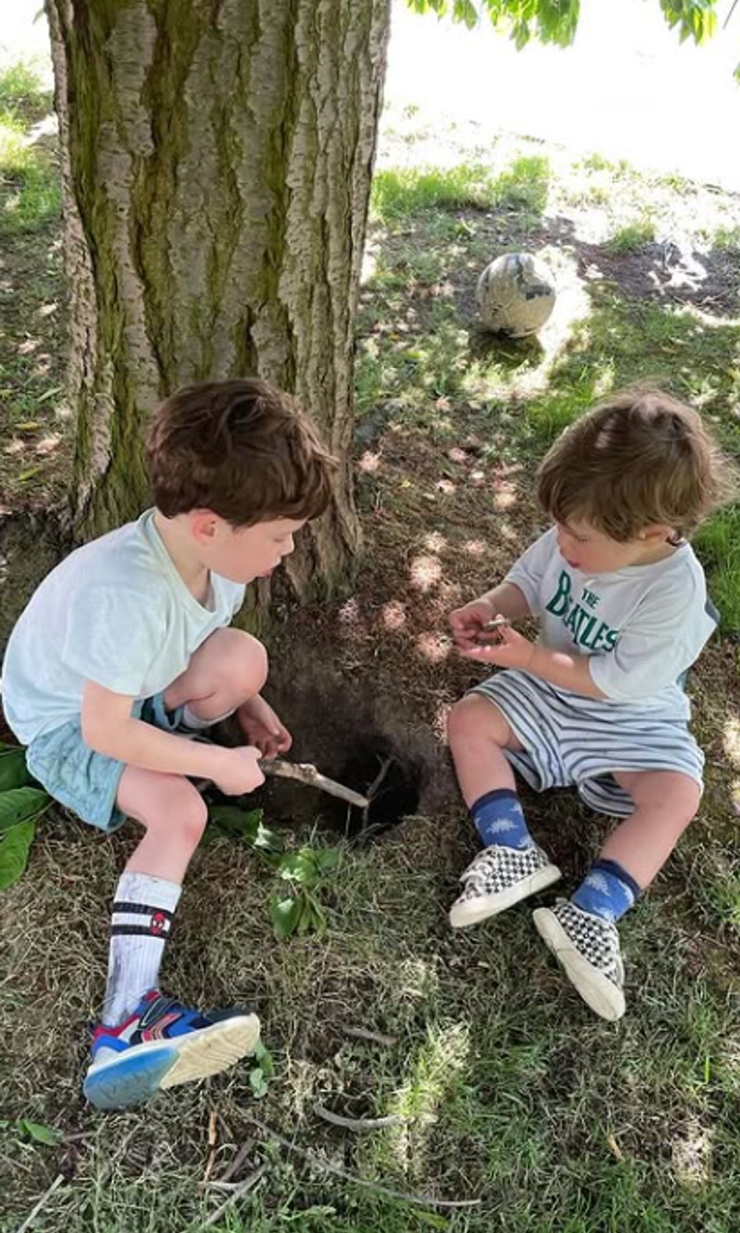 August and Ernest Brooksbank playing by a tree