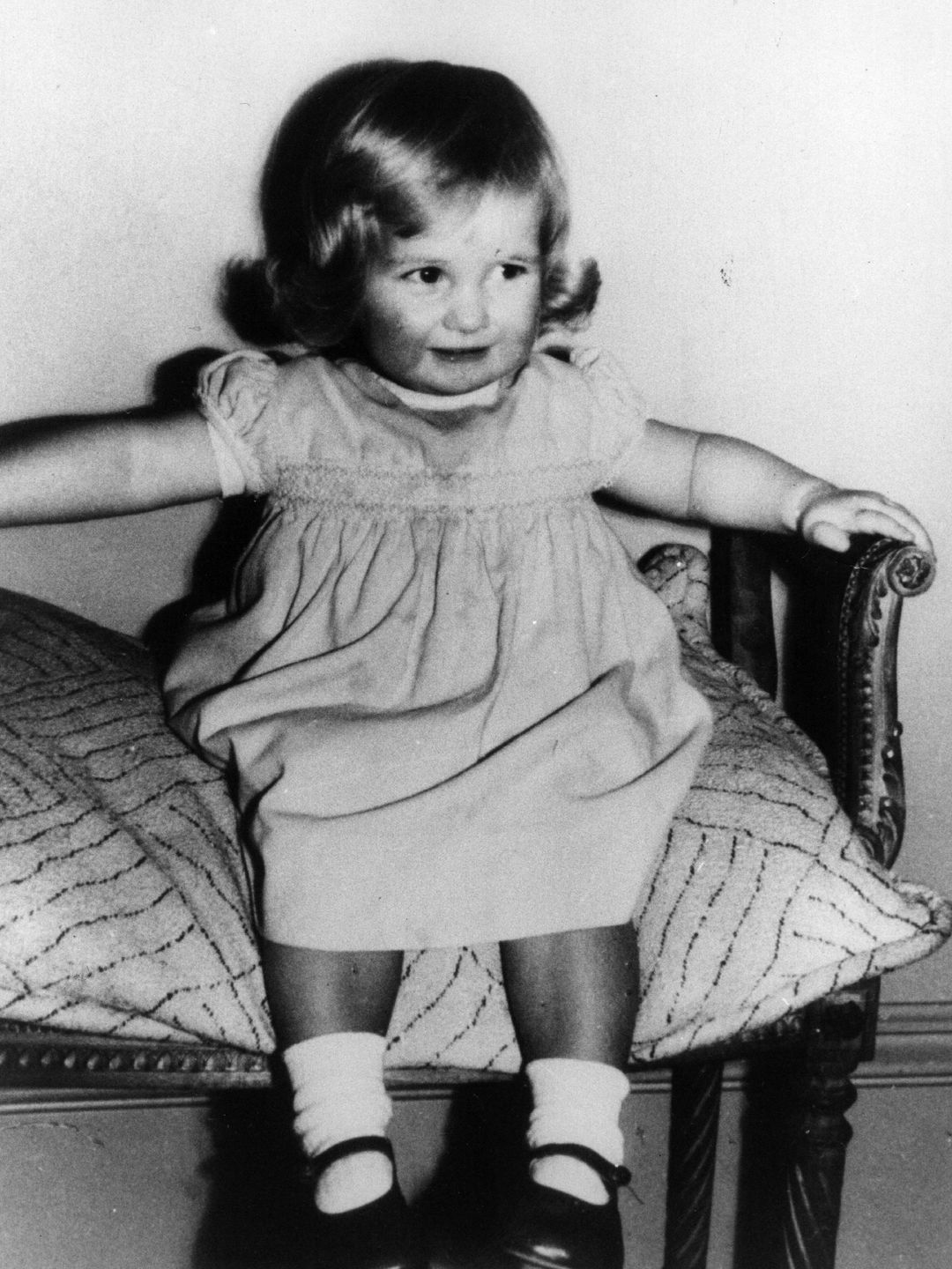 A young Princess Diana on a small sofa
