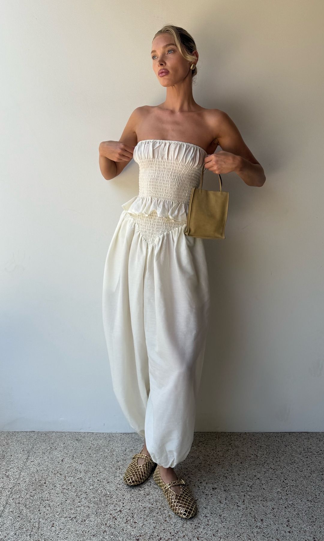 Elsa Hosk poses in a white torusers and a matching strapless top