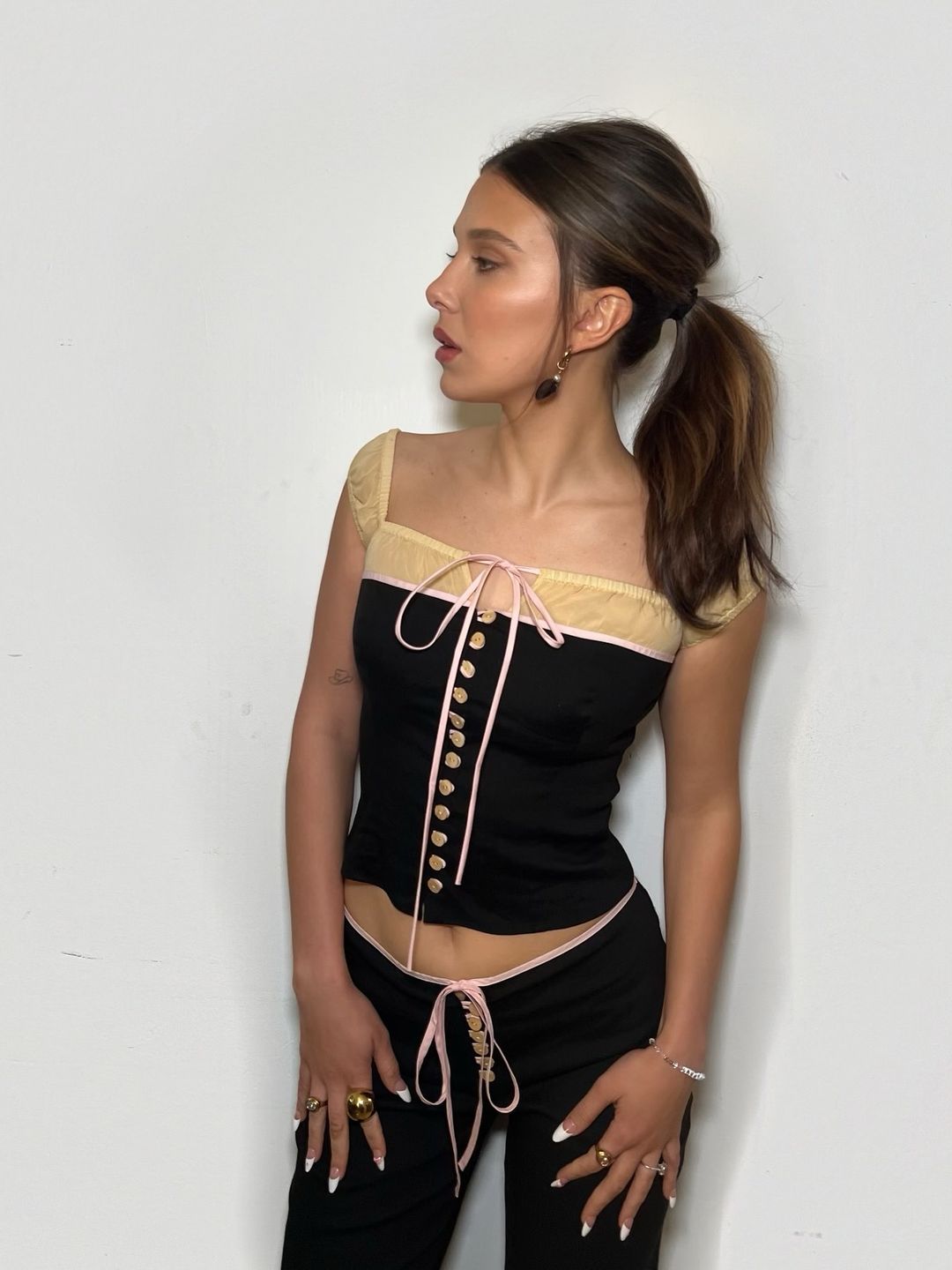 Millie Bobby Brown poses on her Instagram in a corset top and trousers