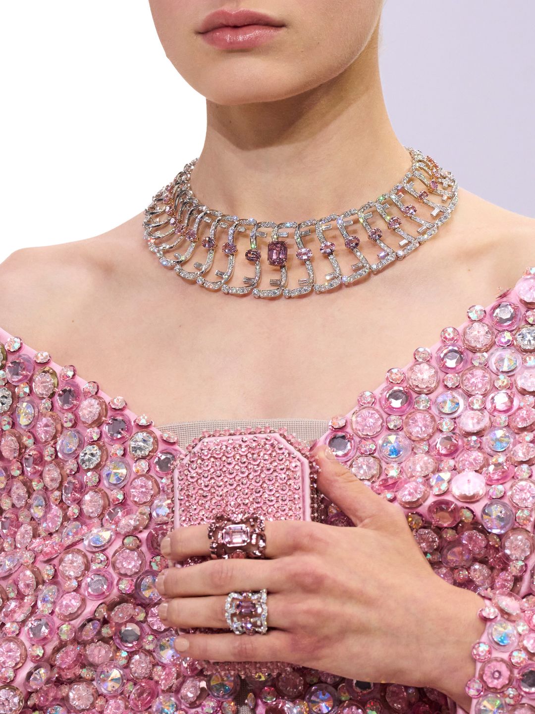 Model wearing dazzling pink dress with statement necklace and ring 