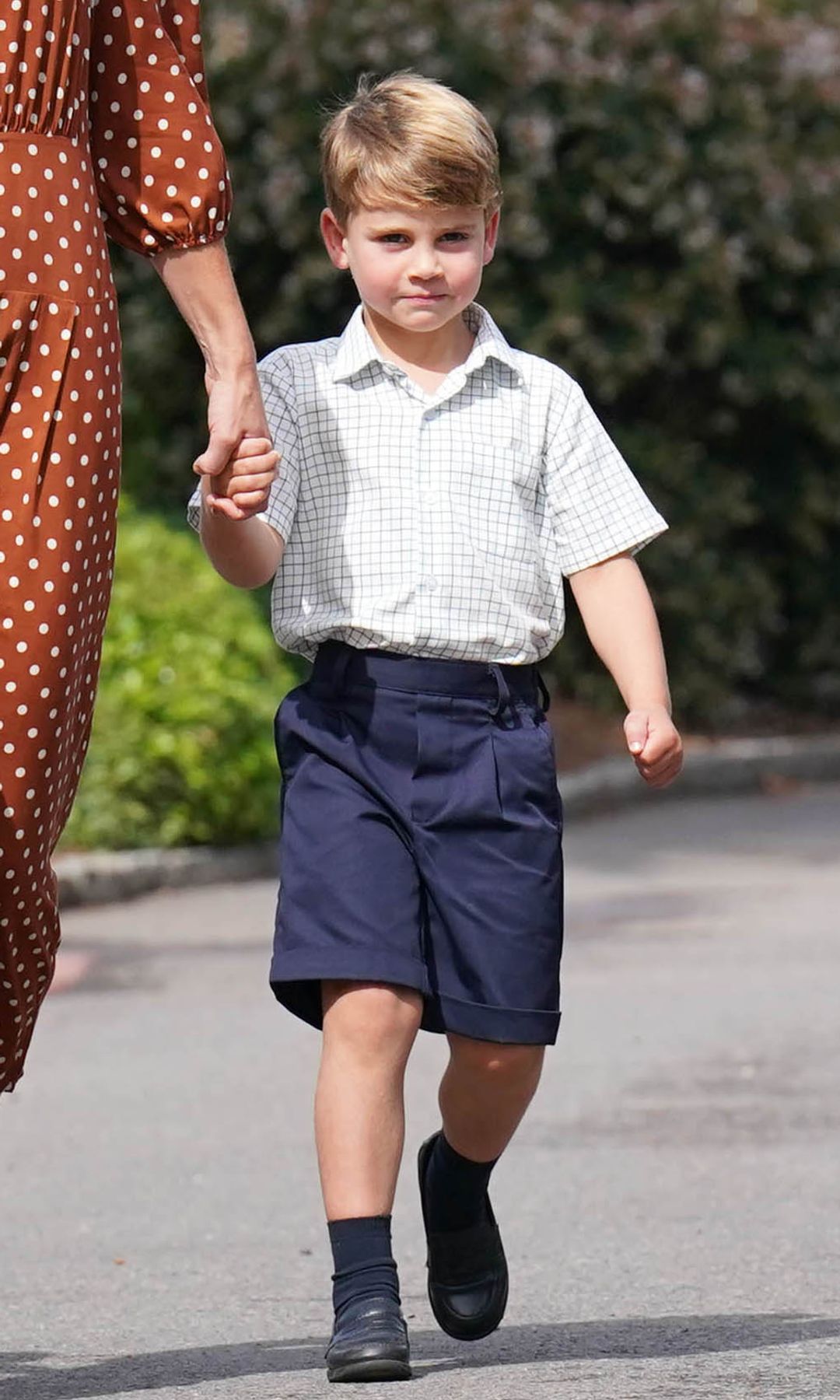 Prince Louis in shorts holding his mother's hand