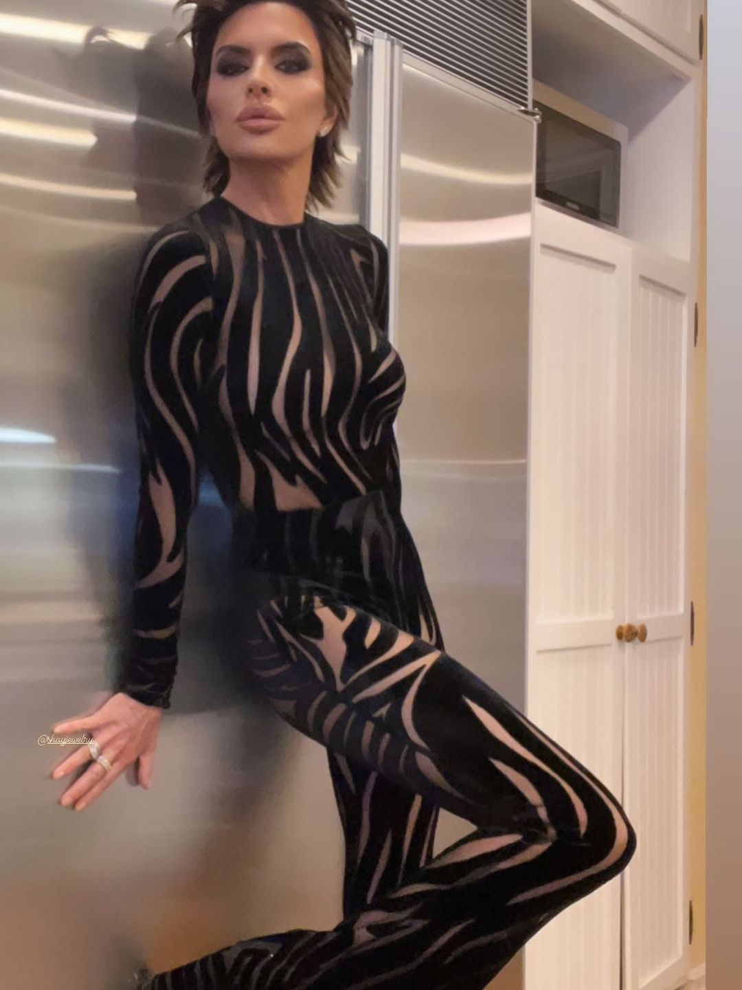Lisa leaning against a wall and posing in the catsuit