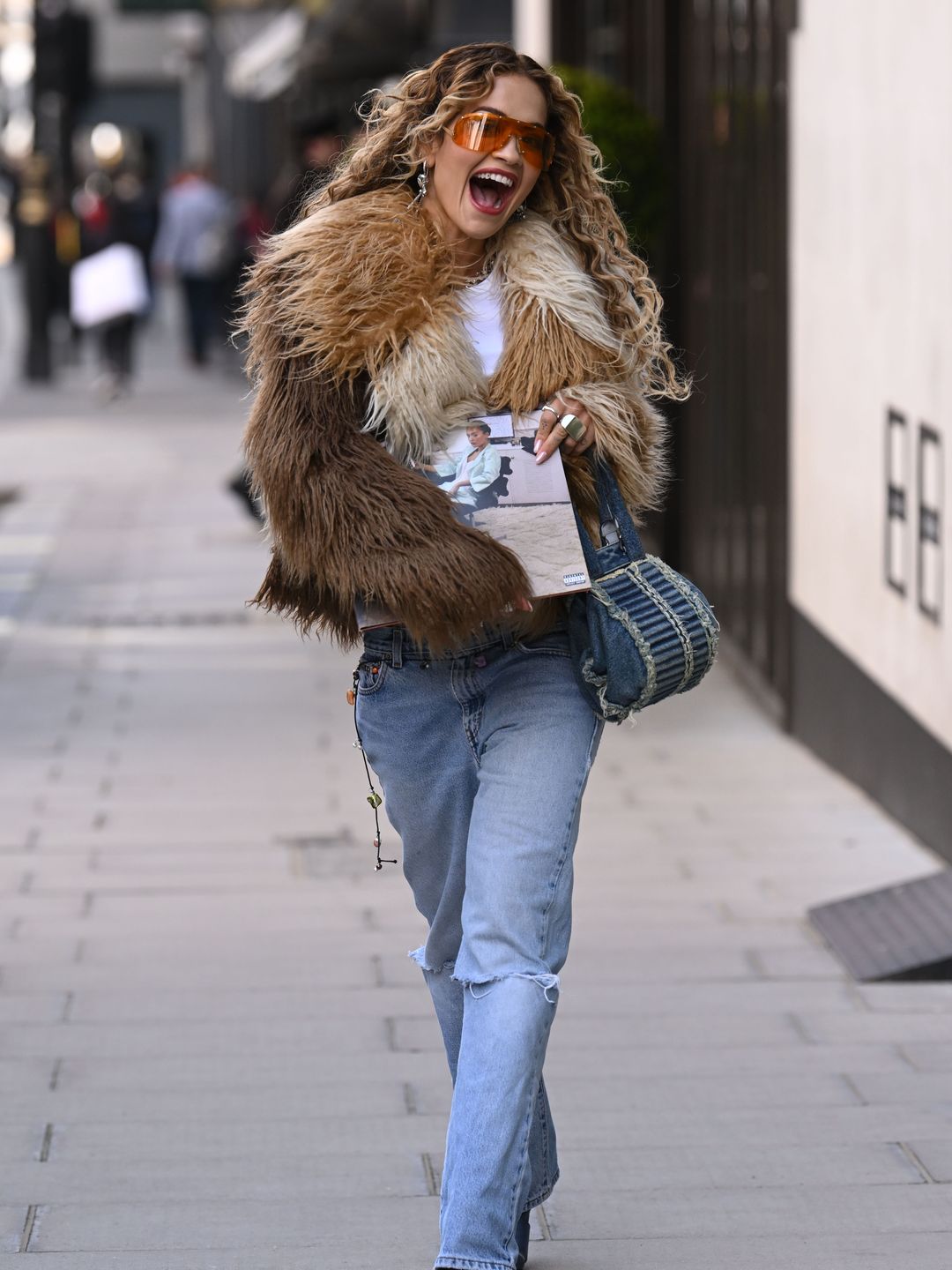 Rita is all smiles as she struts down the streets of London in an effortlessly cool outfit 