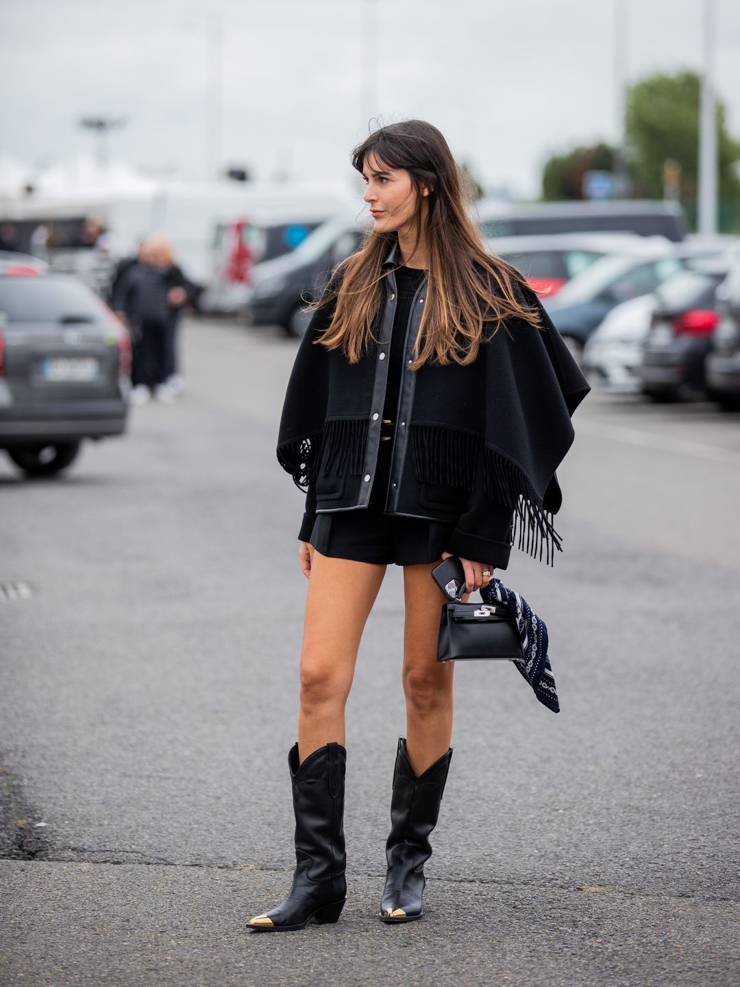 Leia Sfez is styles cowboy boots with a fringed jacket 