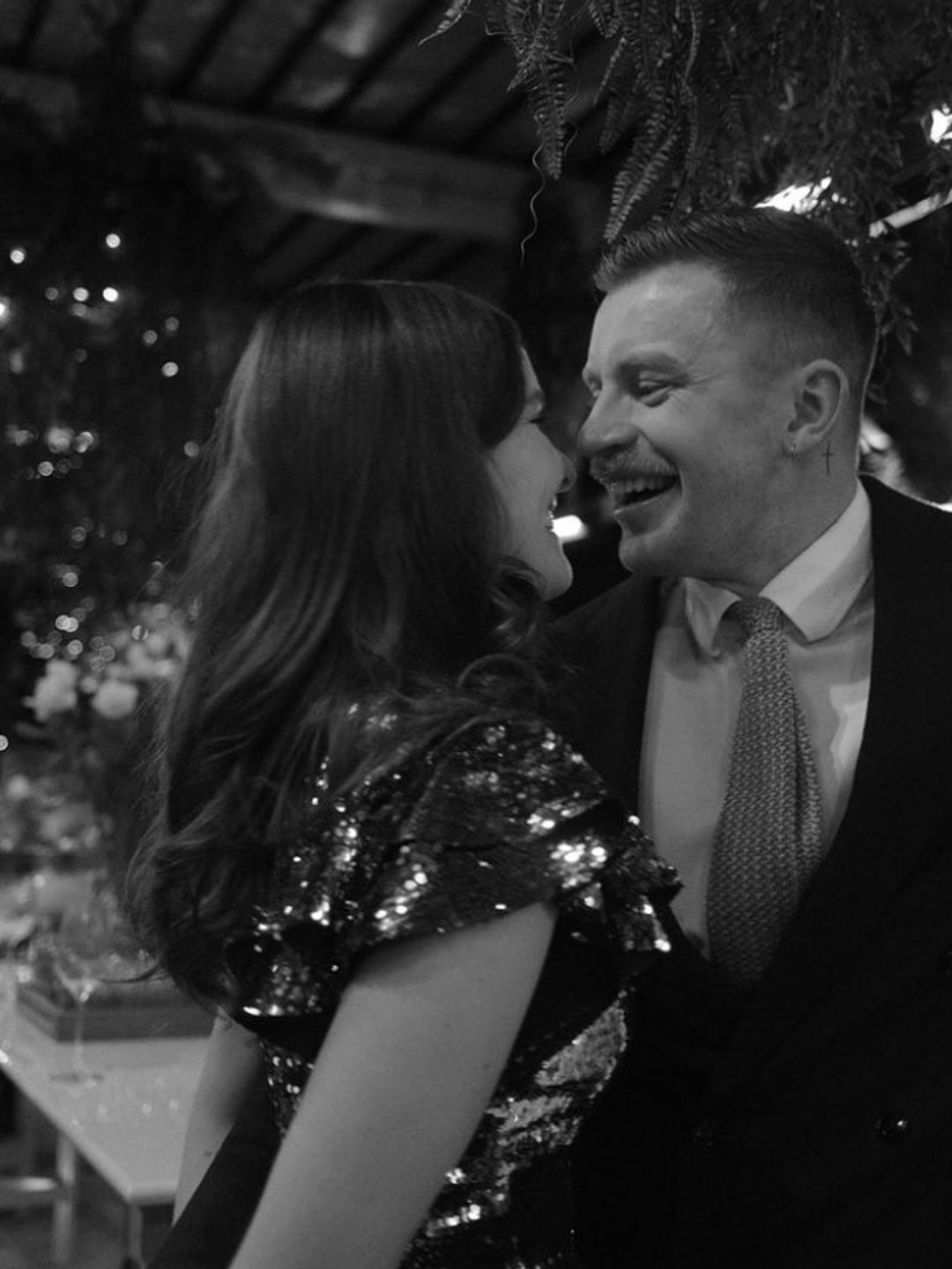 Black and white photo of Adam Peaty and Holly Ramsay underneath mistletoe