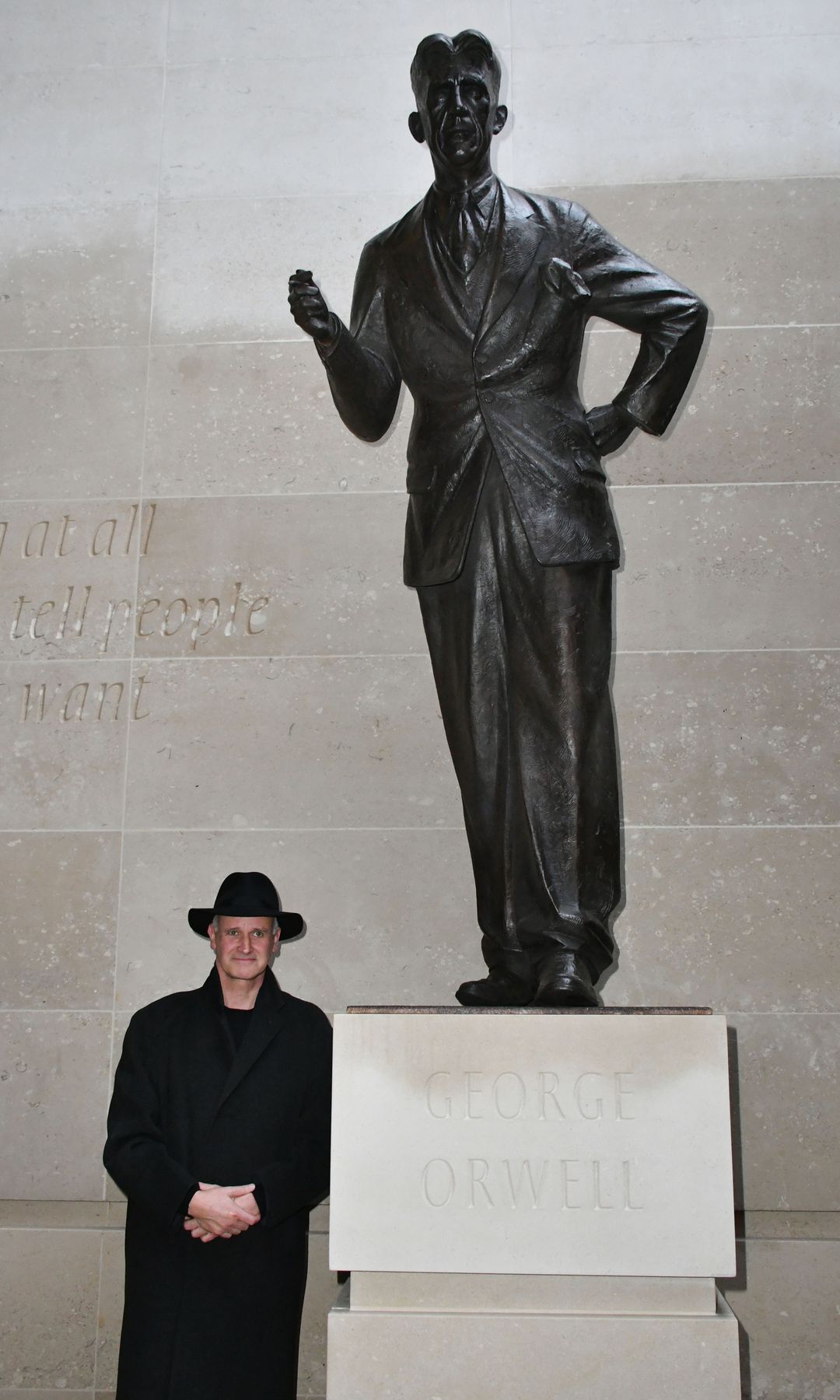 Martin Jennings standing with his statue of George Orwell