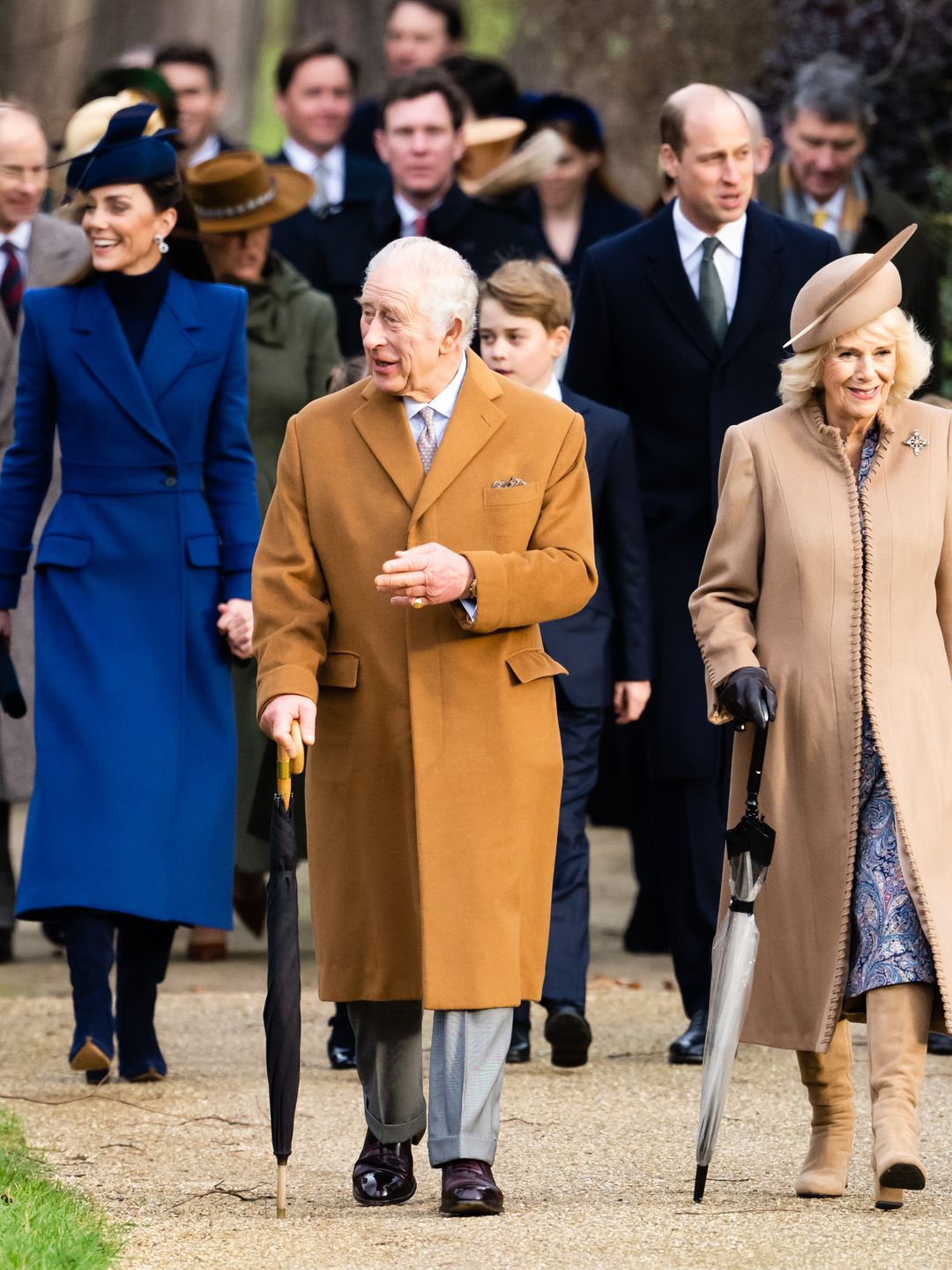 King Charles and Queen Camilla walking with Kate Middleton, Prince George and Prince William behind them
