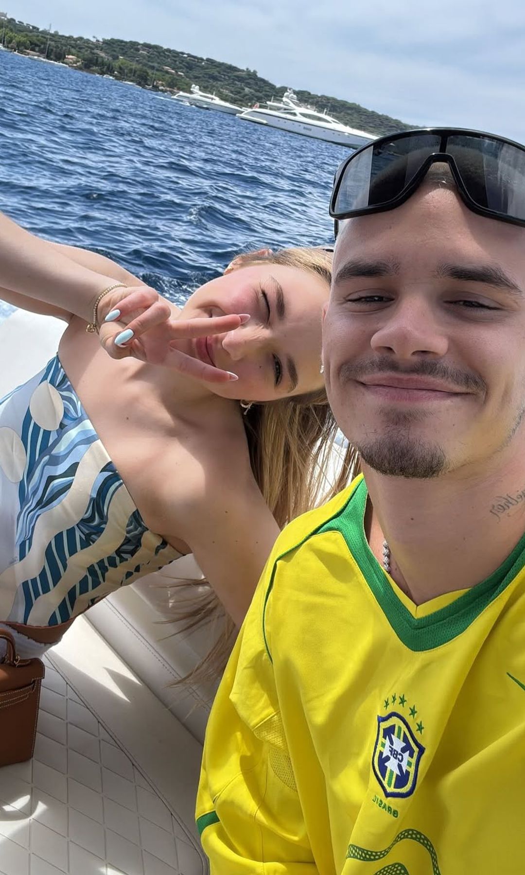 Harper Beckham throwing up a peace sign in a selfie with Romeo on a boat