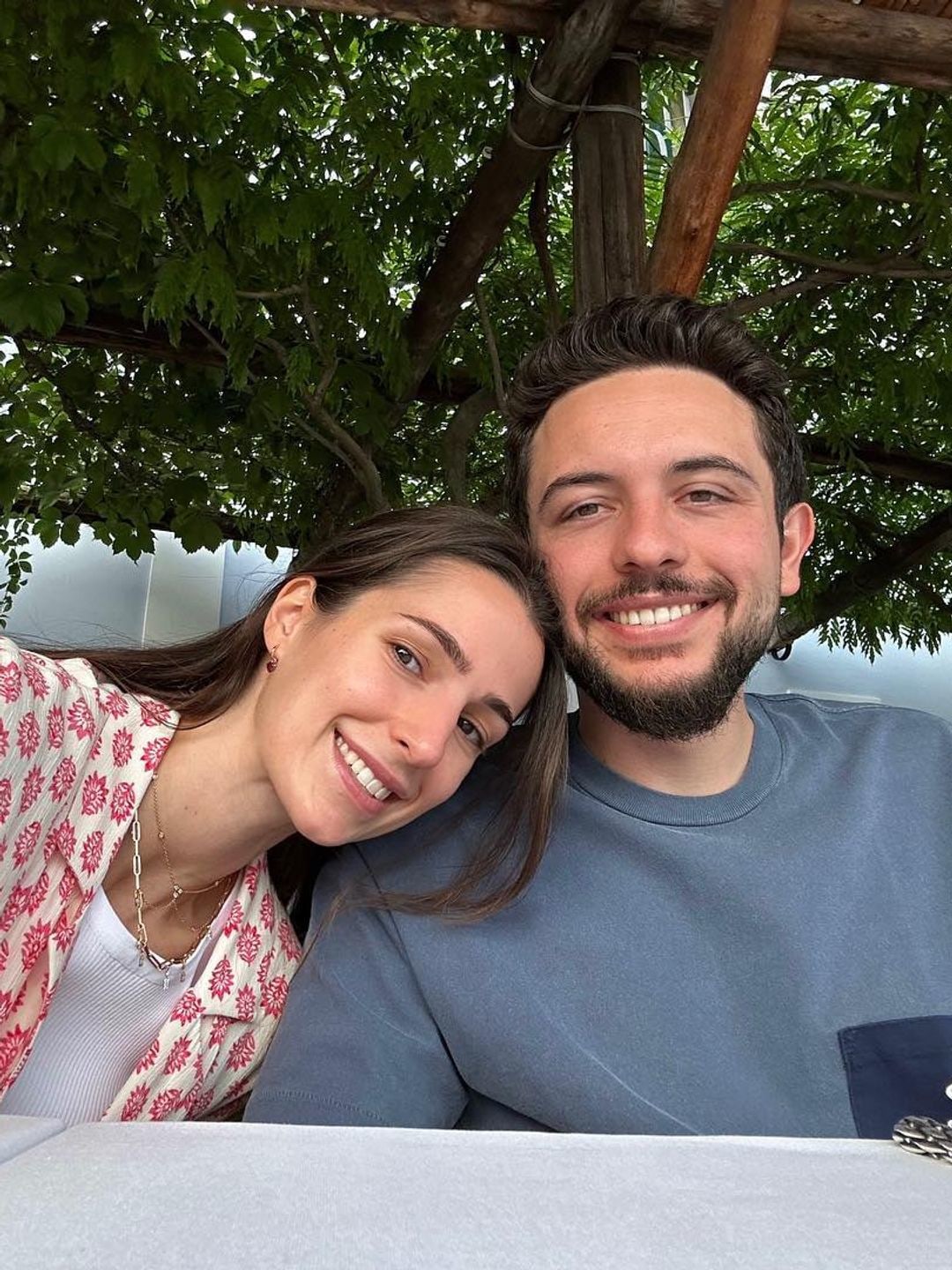 Princess Rjwa and His Royal Highness Crown Prince Al Hussein pose for a selfie. Rajwa wears a cream and pink shirt where Hussein wears a blue t-shirt 