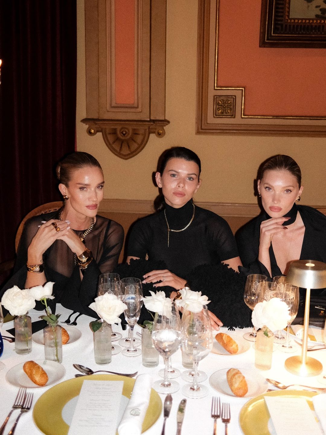 Rosie Huntington Whiteley, Georgia Fowler and Elsa Hosk all sit next to each other in black dresses at a Tiffany & Co. dinner