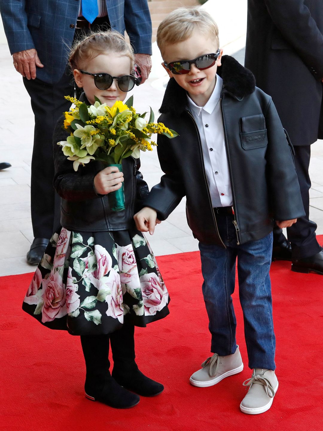 twins on red carpet in leather jackets