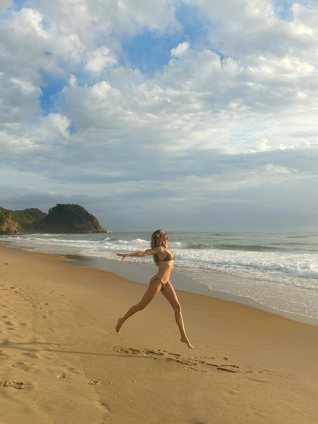 woman leaping in air wearing bikini 