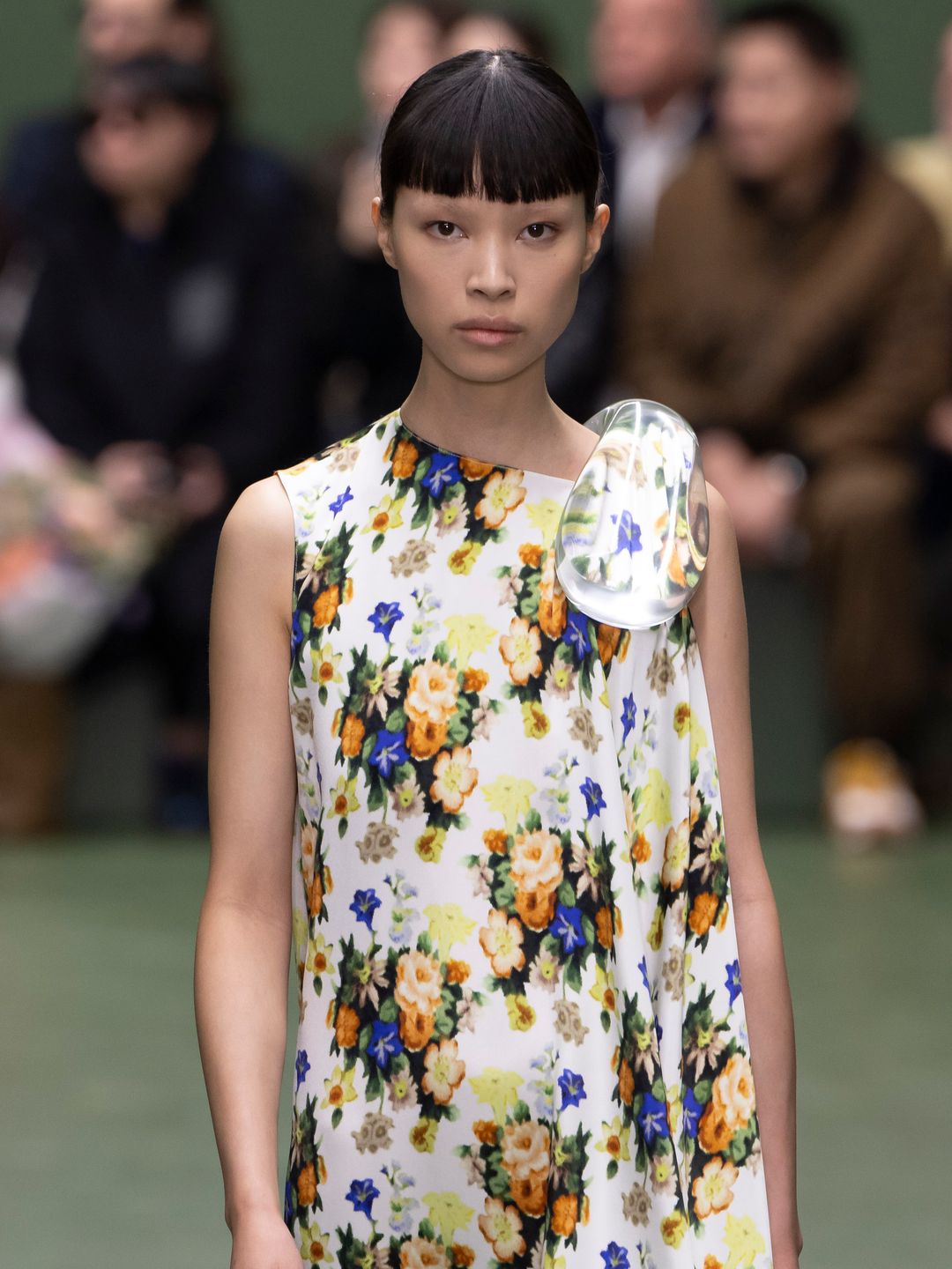 A model walks the runway during the Loewe Ready to Wear Fall/Winter 2024-2025 fashion show wearing a floral silk dress